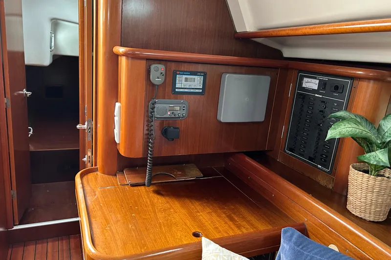 Slide: The Image of 1998 Beneteau 411 yacht interior with navigation equipment and wooden cabinetry. - 6