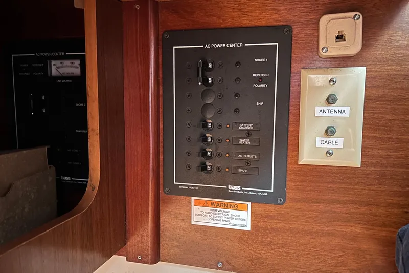 Slide: The Image of Electrical panel on a 1998 Beneteau 411 sailboat, featuring AC power controls and antenna connections. - 7