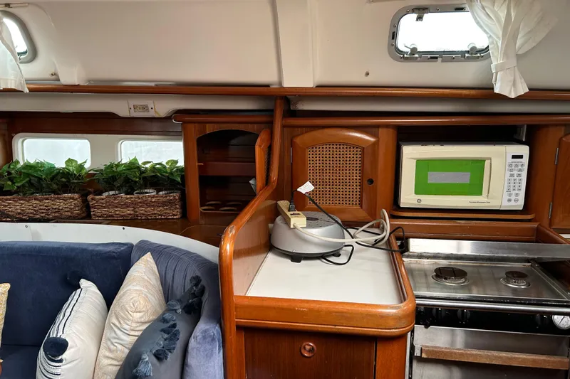 Slide: The Image of Interior of a 1998 Beneteau 411 yacht with kitchen and seating area. - 8