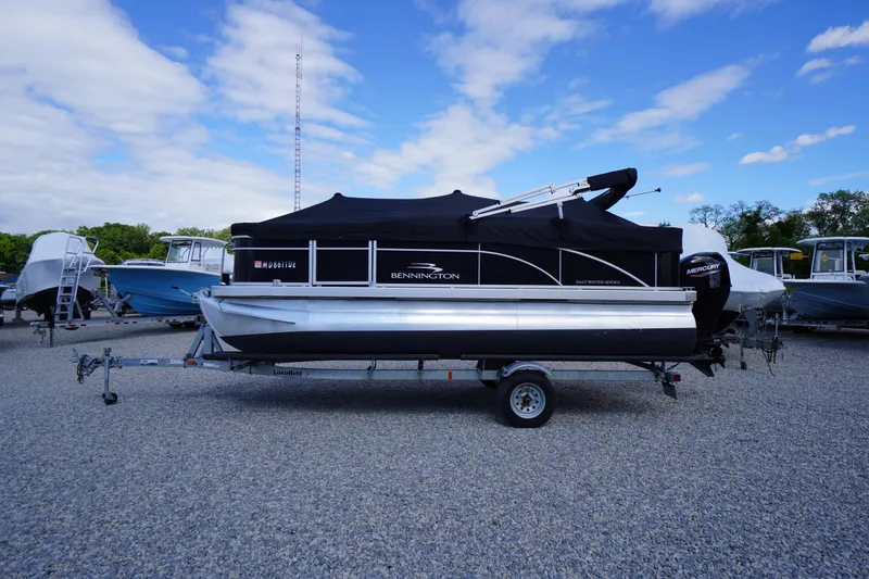 The Image of 2023 Bennington S 18 Fishing boat on trailer, parked outdoors under blue sky. - 0