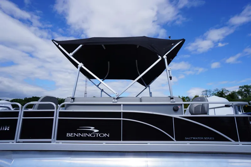 Slide: The Image of 2023 Bennington S 18 Fishing boat with canopy under blue sky. - 2