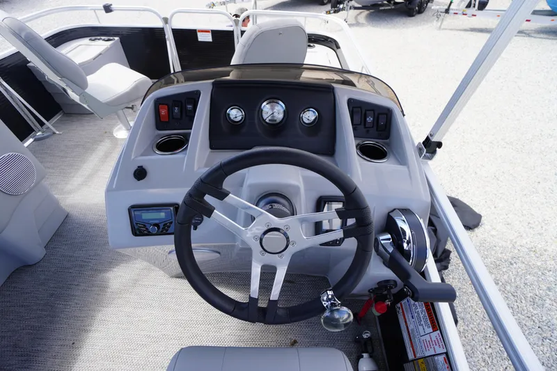 Slide: The Image of 2023 Bennington S 18 Fishing boat dashboard with steering wheel and controls. - 26