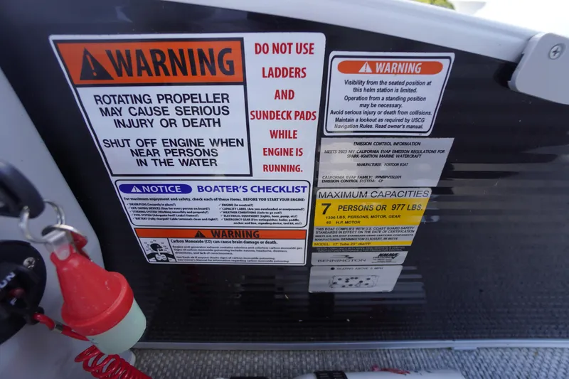 Slide: The Image of Warning labels and capacity information on a 2023 Bennington S 18 Fishing boat. - 32