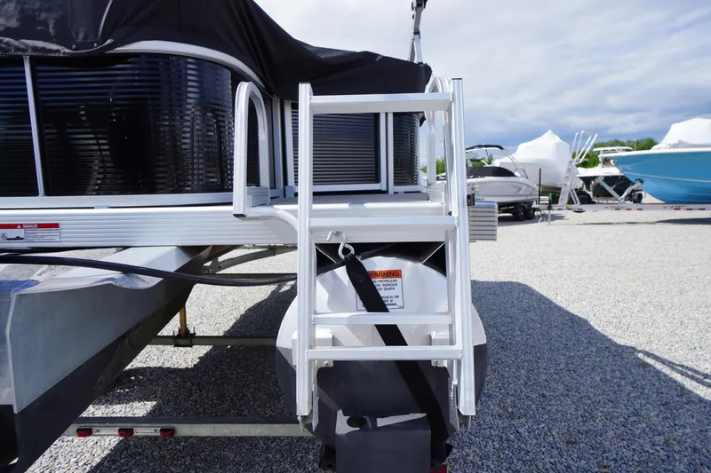 Slide: The Image of 2023 Bennington S 18 Fishing boat with ladder, parked on gravel lot. - 8