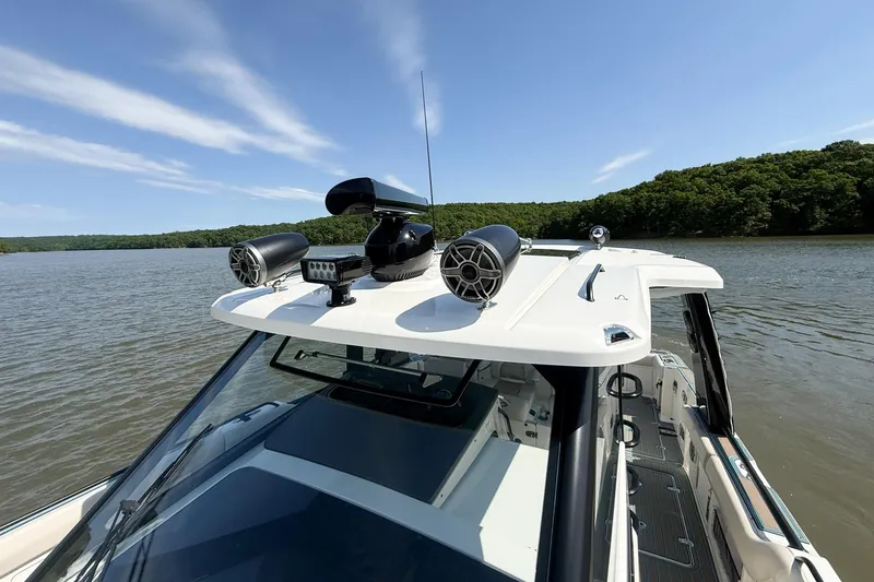 Slide: The Image of 2021 Boston Whaler 420 Outrage on a serene lake, showcasing advanced roof equipment. - 14