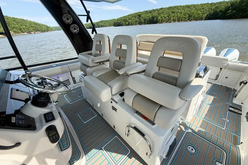 Slide: The Image of 2021 Boston Whaler 420 Outrage boat interior with luxurious seating and scenic lake view. - 16