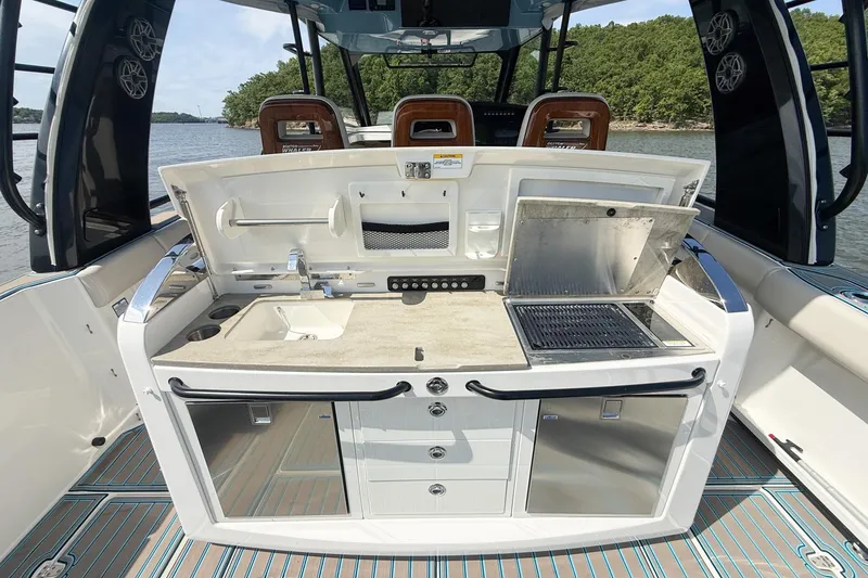 Slide: The Image of 2021 Boston Whaler 420 Outrage boat with outdoor kitchen and grill setup. - 22