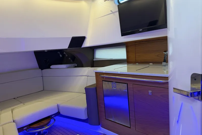 Slide: The Image of Luxurious interior of 2021 Boston Whaler 420 Outrage with seating, kitchenette, and TV. - 31