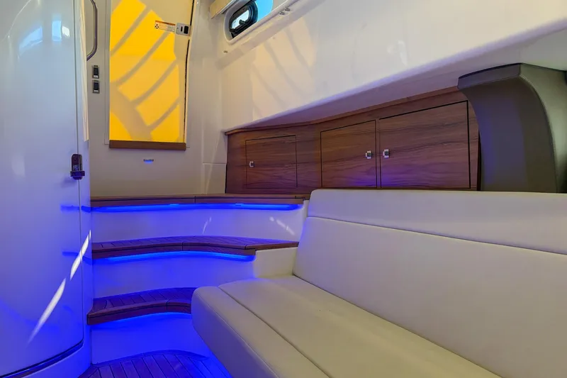 Slide: The Image of Luxurious interior of 2021 Boston Whaler 420 Outrage with ambient blue lighting and wooden accents. - 34