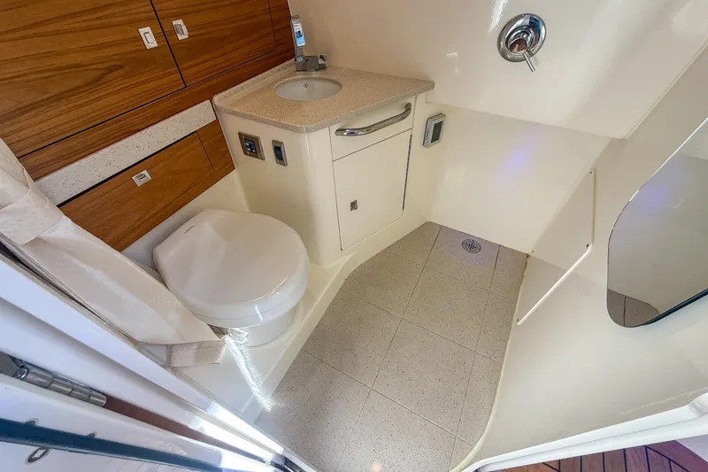 Slide: The Image of 2021 Boston Whaler 420 Outrage bathroom with modern fixtures and wood cabinetry. - 36