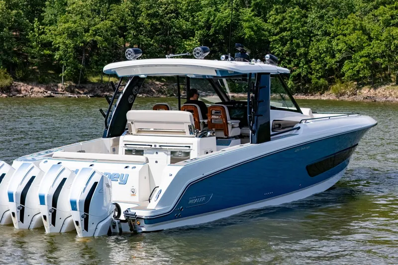 Slide: The Image of 2021 Boston Whaler 420 Outrage boat on water, featuring multiple outboard engines. - 39