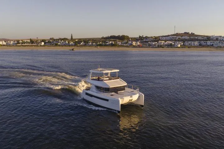 Slide: The Image of Manufacturer Provided Image: 2025 Leopard 40 Powercat cruising on calm waters near a coastal town. - 6