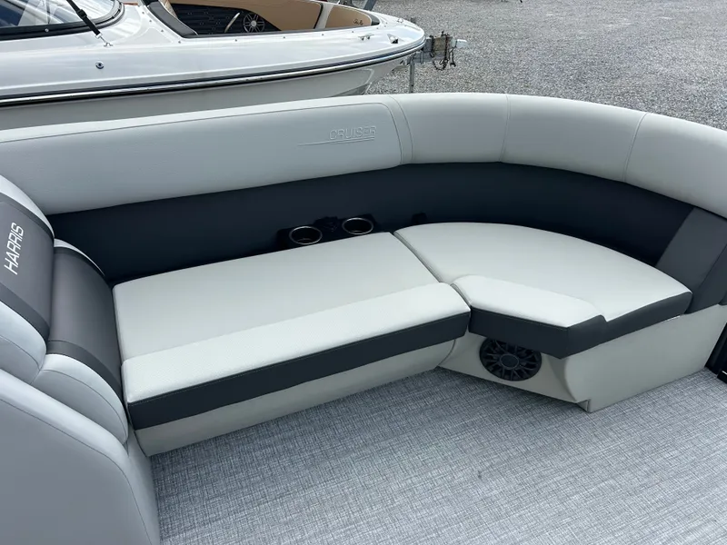 Slide: The Image of The 2027 Harris Cruiser 230 features a sleek, gray seating area with cup holders. - 17
