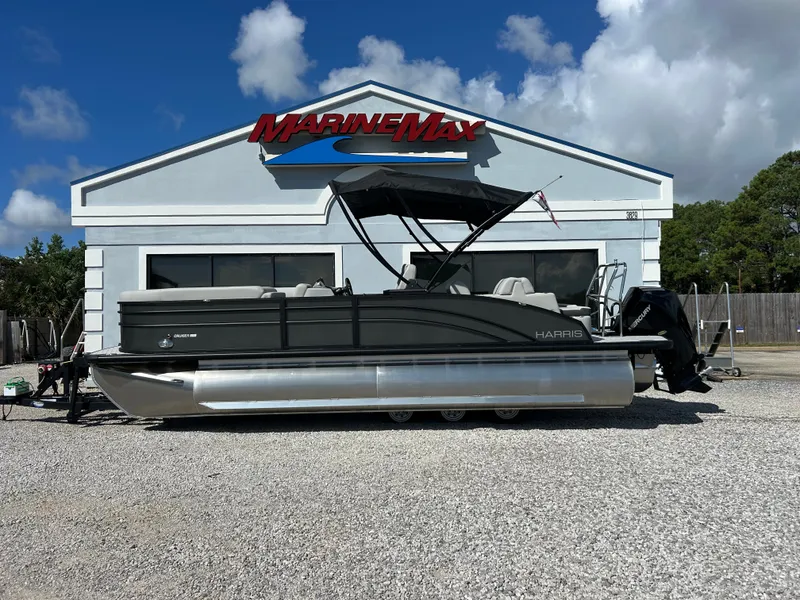 Slide: The Image of A Harris Cruiser 230 pontoon boat is parked in front of a building with a MarineMax logo. - 1