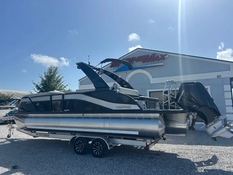 Slide: The Image of A modern Harris Grand Mariner 250 pontoon boat on a trailer in front of a building. - 4