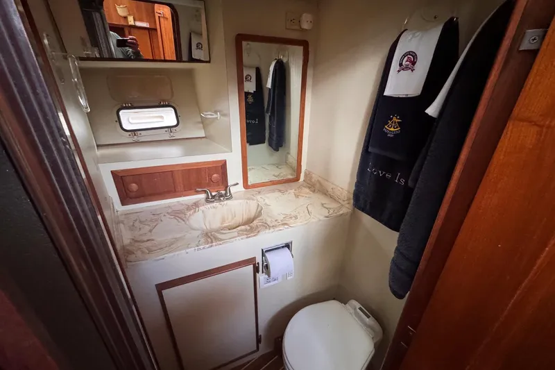 Slide: The Image of 1987 Chris-Craft 44 Commander bathroom with sink, mirror, and towels. - 14