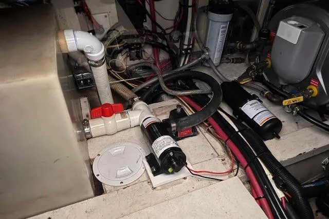 Slide: The Image of Engine room of 1987 Chris-Craft 44 Commander with visible plumbing and wiring components. - 18