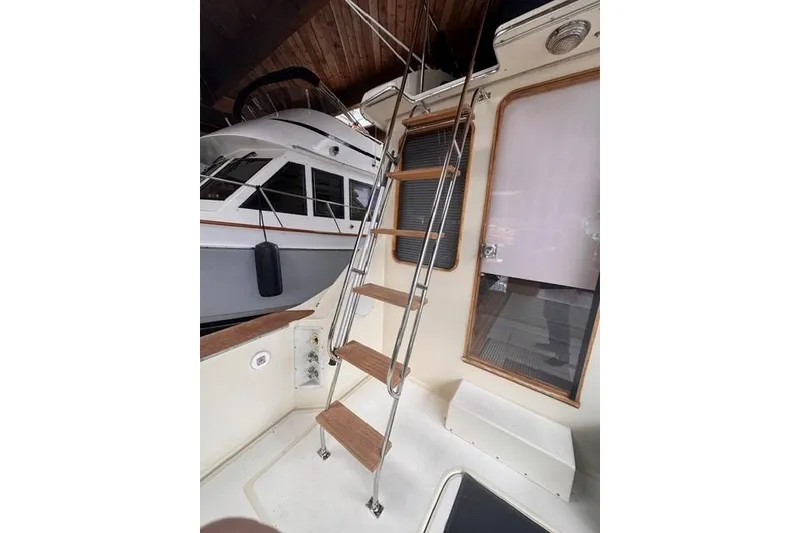 Slide: The Image of 1987 Chris-Craft 44 Commander yacht interior with wooden ladder and window view. - 4