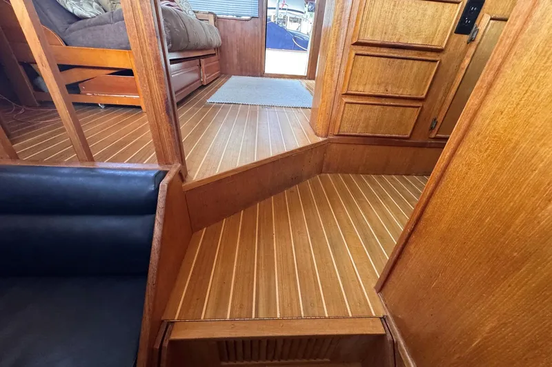 Slide: The Image of Interior of 1987 Chris-Craft 44 Commander with wooden flooring and cozy seating area. - 7