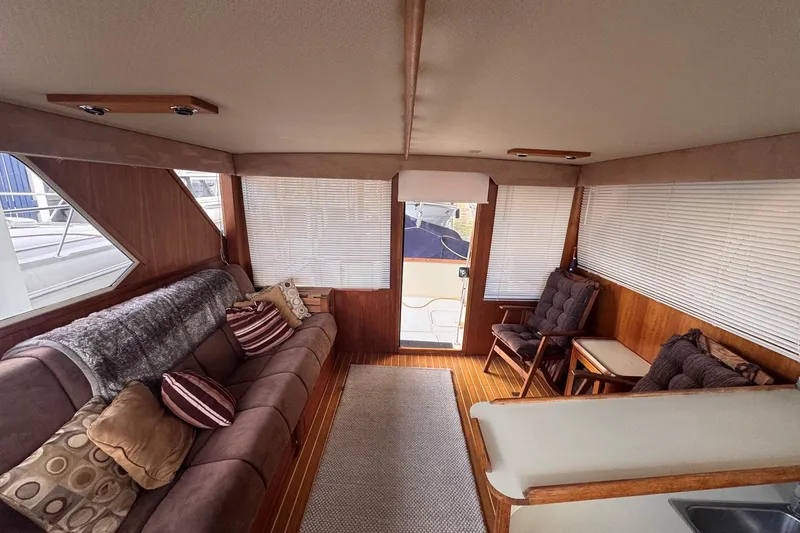 Slide: The Image of Luxurious interior of 1987 Chris-Craft 44 Commander yacht with plush seating and wooden accents. - 9