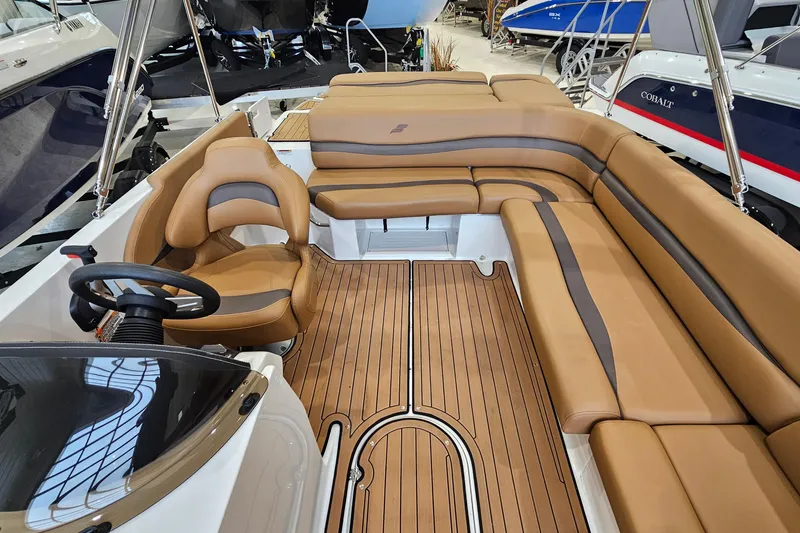 Slide: The Image of 2022 Starcraft Star Step 221 E I/O boat interior with tan seating and wood-style flooring. - 10