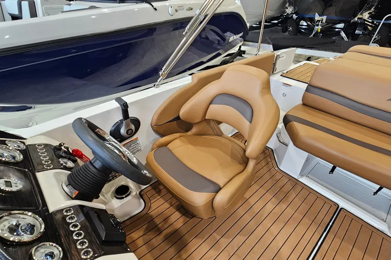 Slide: The Image of 2022 Starcraft Star Step 221 E I/O boat interior with tan seating and modern dashboard. - 11