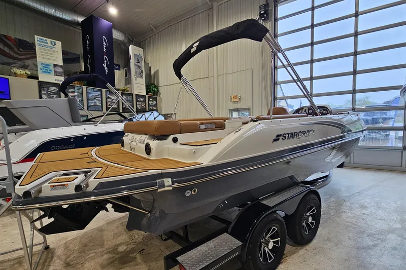 Slide: The Image of 2022 Starcraft Star Step 221 E I/O boat displayed indoors on a trailer. - 3