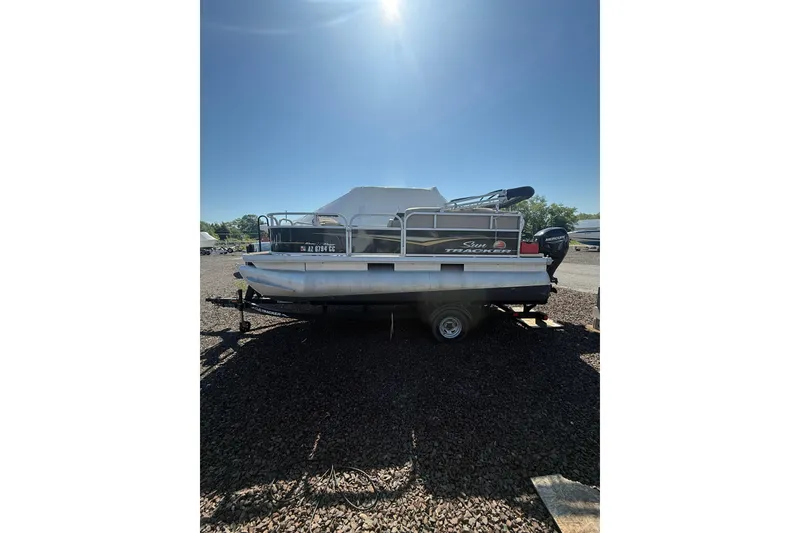 The Image of 2021 Sun Tracker Bass Buggy 16 XL Select pontoon boat on trailer under bright sun. - 1