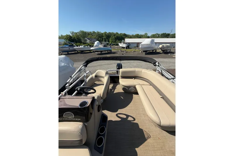 Slide: The Image of 2021 Sun Tracker Bass Buggy 16 XL Select pontoon boat with beige seating and steering console. - 16