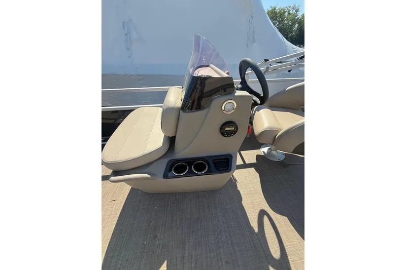 Slide: The Image of 2021 Sun Tracker Bass Buggy 16 XL Select boat console with beige seating and steering wheel. - 17