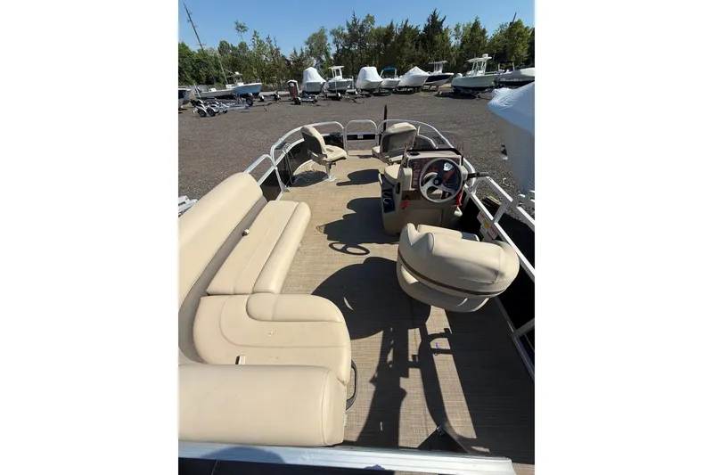 Slide: The Image of 2021 Sun Tracker Bass Buggy 16 XL Select pontoon boat with beige seating and steering console. - 19