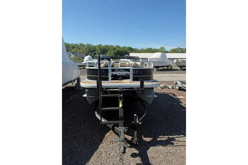 Slide: The Image of 2021 Sun Tracker Bass Buggy 16 XL Select pontoon boat on trailer in outdoor lot. - 3