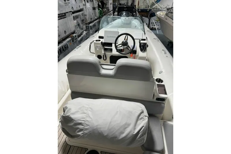 Slide: The Image of 2025 Zodiac Medline 7.5 boat interior with steering wheel and seating, featuring Garmin equipment. - 8