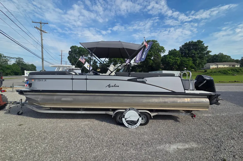 Slide: The Image of 2021 Avalon 2585 Catalina QL pontoon boat on trailer, parked outdoors under blue sky. - 1