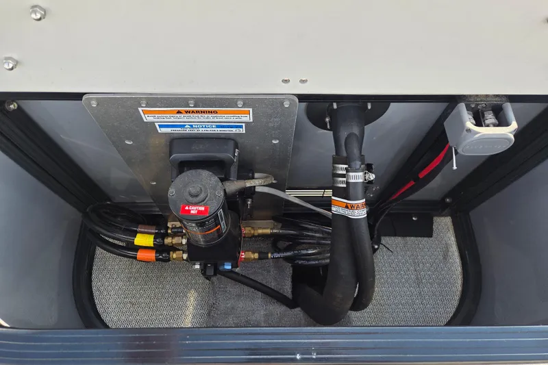 Slide: The Image of 2021 Avalon 2585 Catalina QL engine compartment with hoses and warning labels. - 12