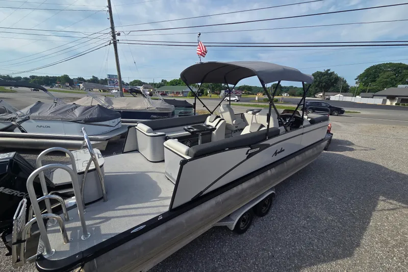 Slide: The Image of 2021 Avalon 2585 Catalina QL pontoon boat with canopy, parked on a trailer. - 3