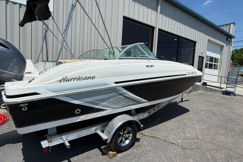 Slide: The Image of 2016 Hurricane SunDeck 187 OB boat on trailer outside a metal building. - 1