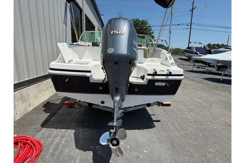 Slide: The Image of 2016 Hurricane SunDeck 187 OB boat with outboard motor, parked outdoors. - 2