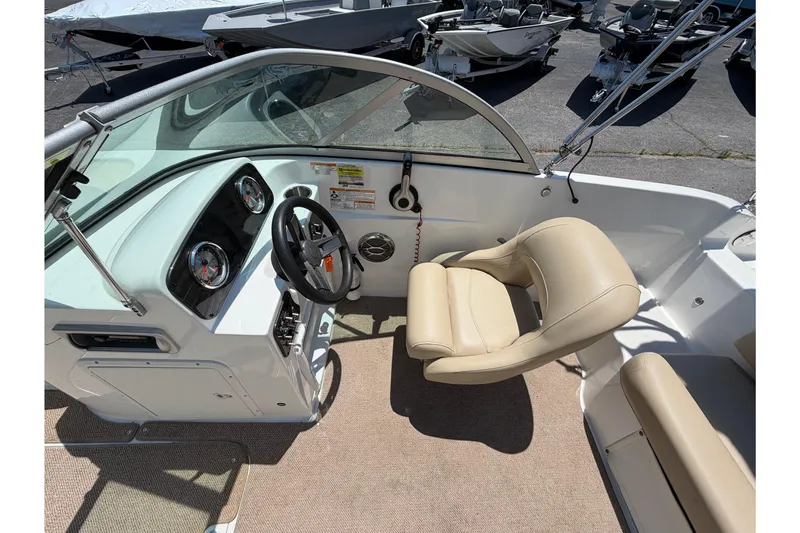 Slide: The Image of 2016 Hurricane SunDeck 187 OB boat interior with steering wheel and beige seating. - 6