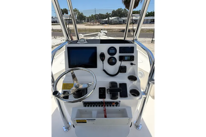 Slide: The Image of 2024 Key West 230 Bay Reef boat console with steering wheel and navigation controls. - 12