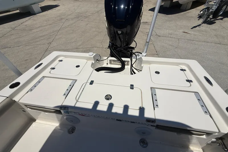 Slide: The Image of 2024 Key West 230 Bay Reef boat deck with storage compartments and outboard motor. - 16