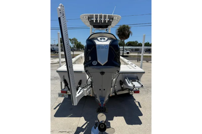 Slide: The Image of 2024 Key West 230 Bay Reef boat, rear view with outboard motor, parked on a trailer. - 3