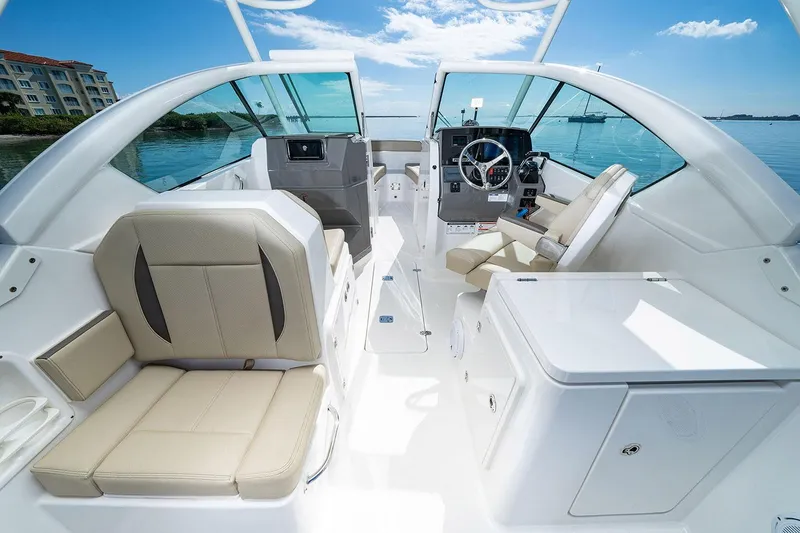 Slide: The Image of Manufacturer Provided Image: 2025 Pursuit DC 266 Dual Console boat interior with beige seating and modern dashboard. - 8