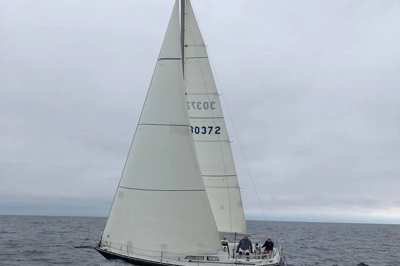 The Image of 1981 C&C 34 sailboat navigating open waters under cloudy skies. - 0