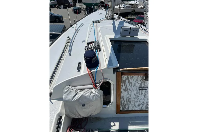 Slide: The Image of 1981 C&C 34 sailboat deck with ropes and equipment in a marina setting. - 10
