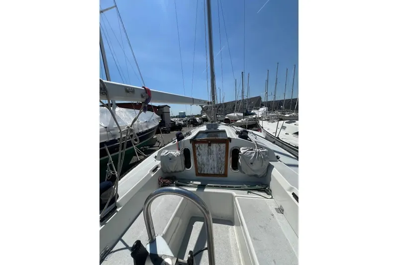 Slide: The Image of 1981 C&C 34 sailboat deck view in marina under clear blue sky. - 11