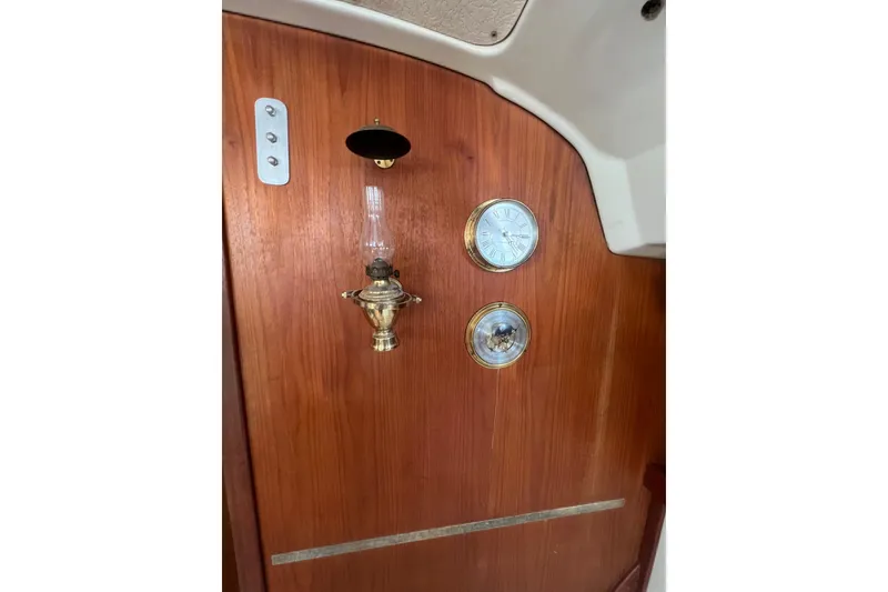 Slide: The Image of Wooden interior of 1981 C&C 34 yacht with brass lamp and clock. - 14