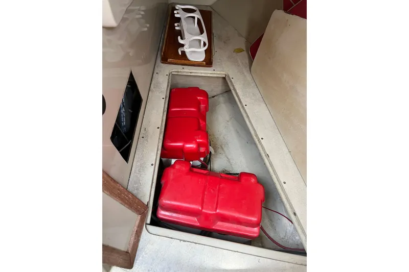 Slide: The Image of Open compartment in 1981 C&C 34 boat with red fuel tanks and white storage rack. - 17