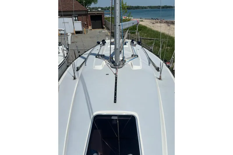 Slide: The Image of 1981 C&C 34 sailboat deck with rigging, near a beach and marina. - 8