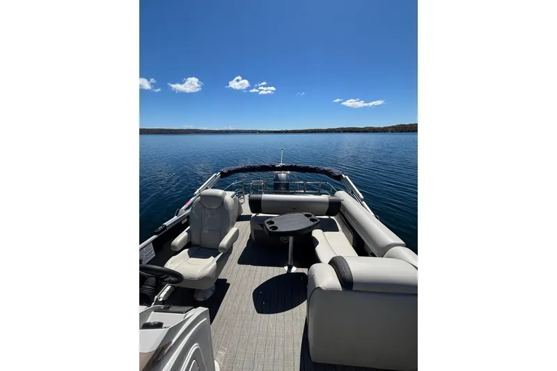 Slide: The Image of 2022 Starcraft EX 22 Q pontoon boat on a serene lake under clear blue skies. - 13